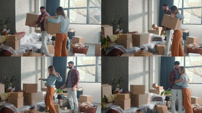 后视年轻快乐浪漫的情侣提着纸箱在新宽敞的公寓里移动，拥抱和微笑庆祝。