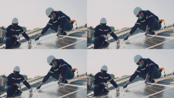 亚洲工人在房屋屋顶上安装太阳能电池板。
