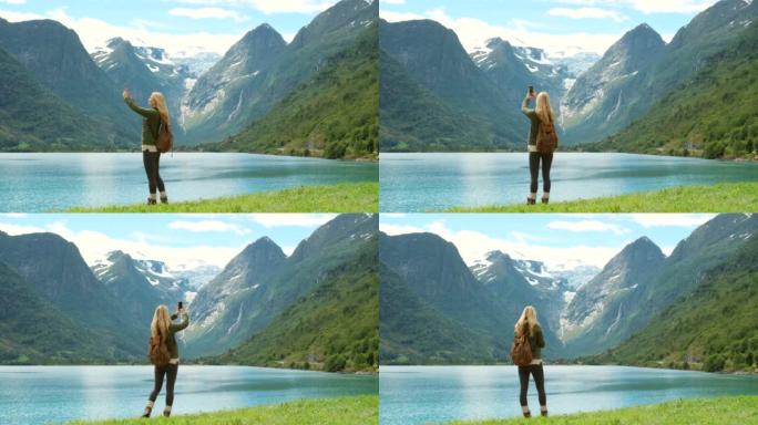 4k视频片段，一个无法识别的女人站着并在Sogn og Fjordane的手机上拍照
