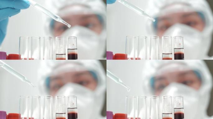 戴着手套和白色实验室外套的女人的手拿着滴管将彩色液体滴入玻璃试管中