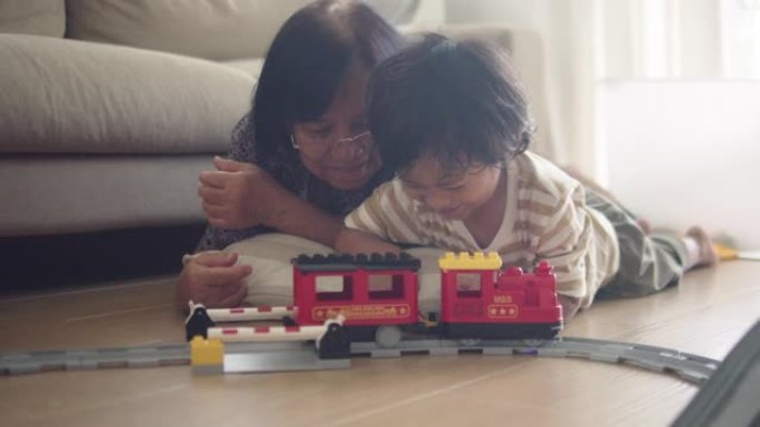 亚洲家庭正在客厅一起修建铁轨。