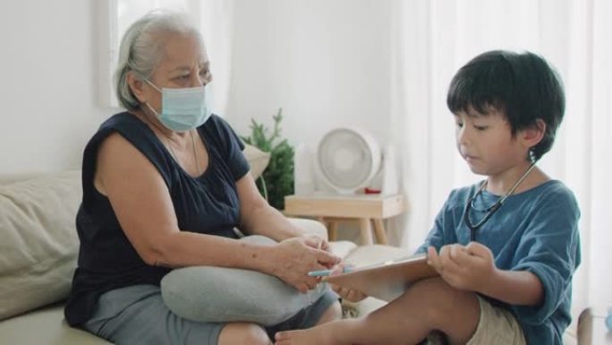 高级妇女和孙子检疫呆在家里。