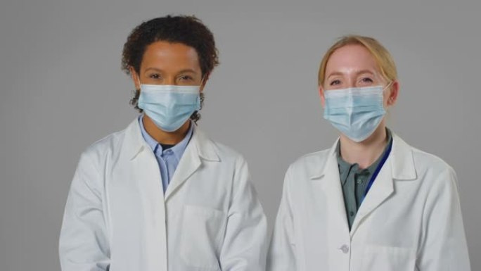 两名穿着白大褂戴着口罩的女医生或实验室工作人员的工作室肖像