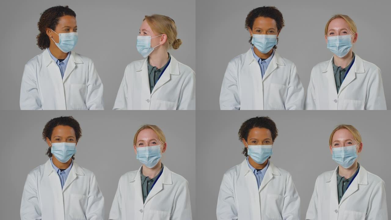 两名穿着白大褂戴着口罩的女医生或实验室工作人员的工作室肖像