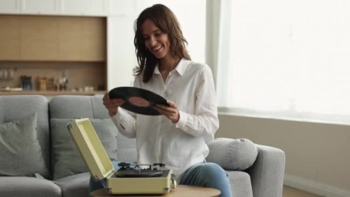 女人在转盘上放唱片，在家玩黑胶唱片