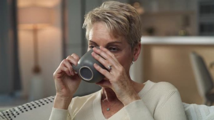 4k视频片段，一名高级妇女坐在家里喝杯咖啡