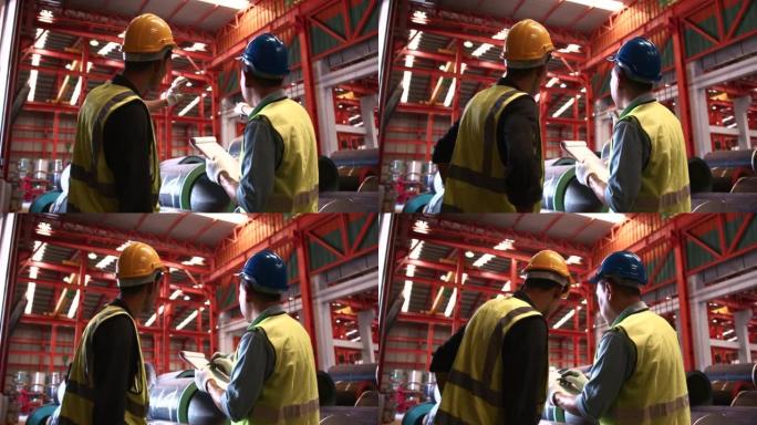 两名头戴安全帽的仓库工人检查制成品