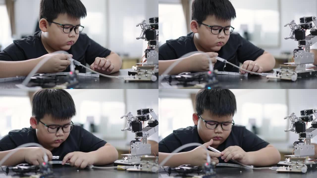 男孩建造和研究机器人STEM编程软件和修复