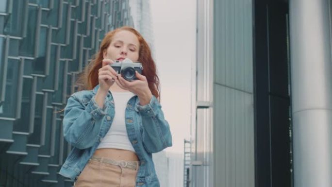 城市中的年轻女子在数码相机上拍照以发布到社交媒体上