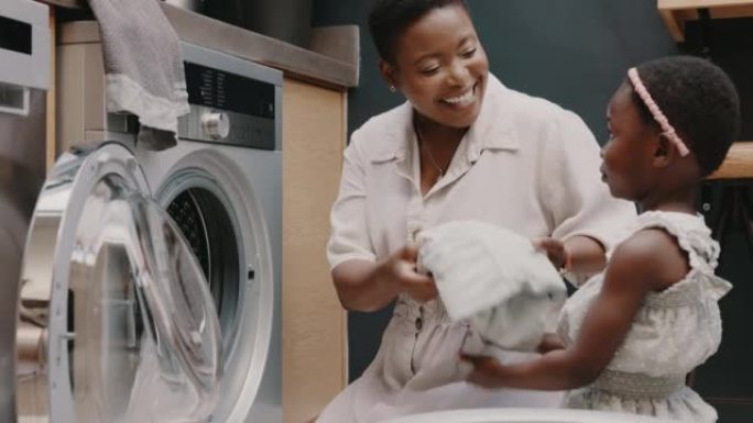 洗衣房，母亲和孩子在房子里帮助折叠衣服。快乐，兴奋和年轻的女孩在家里用洗衣机清洗衣服时向妈妈提供帮助