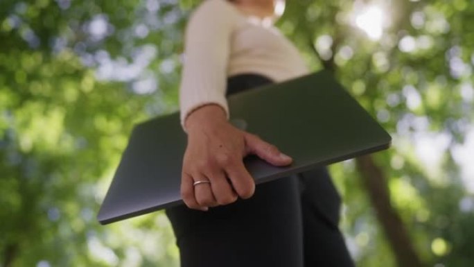 站在城市大街上的女人拿着笔记本电脑