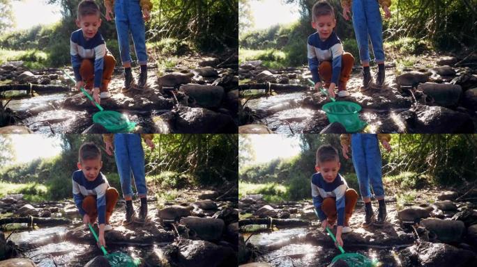 小男孩和女孩用网在河里抓鱼