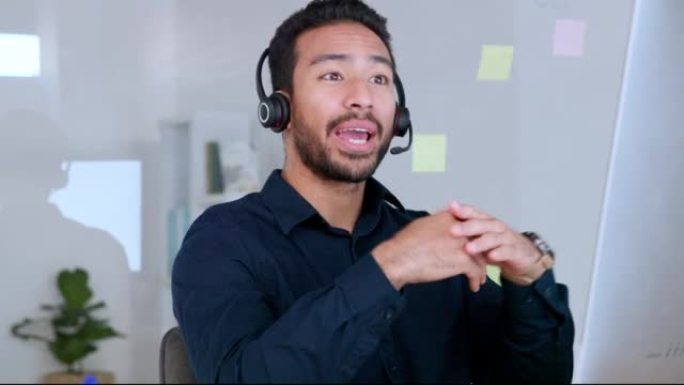 男性呼叫中心代理在办公室工作时在耳机上交谈并解释产品。自信开朗的推销员看着电脑，为客户服务和支持提供