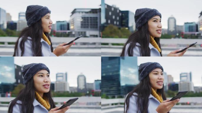 亚洲妇女在智能手机上散步和聊天