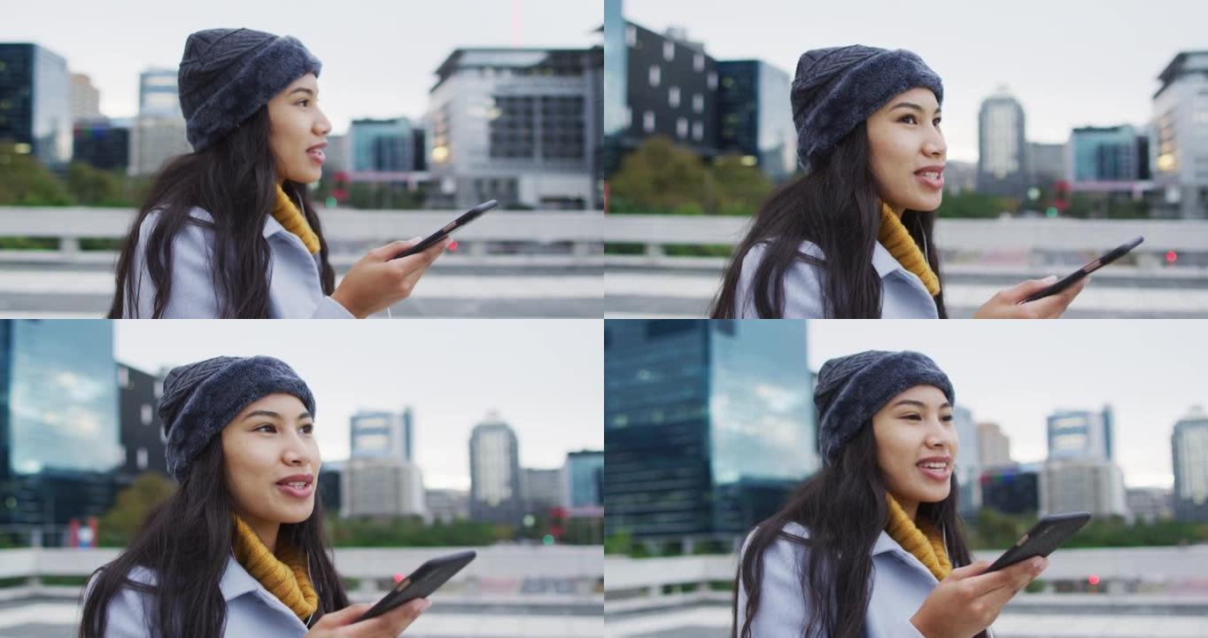 亚洲妇女在智能手机上散步和聊天