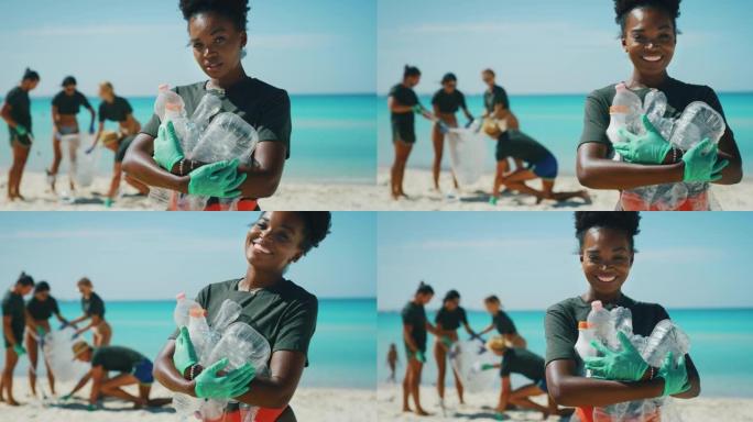 一位年轻的非洲女志愿者的慢动作在镜头前微笑着，对在大海的海滩上捡起塑料垃圾以保护环境感到满意。