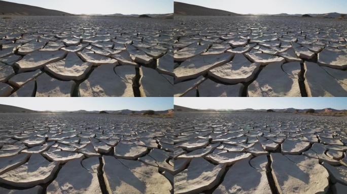 气候变化。由于气候变化和全球变暖造成的干旱，干旱大坝的图案化开裂的泥浆表面的平移特写视图