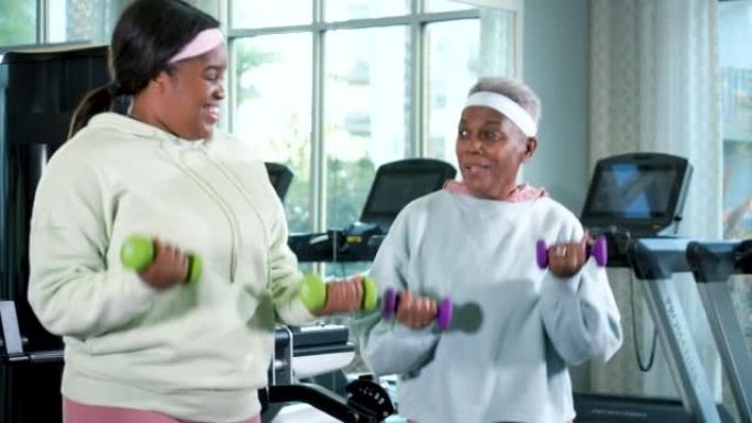高级黑人妇女和女儿在健身房锻炼