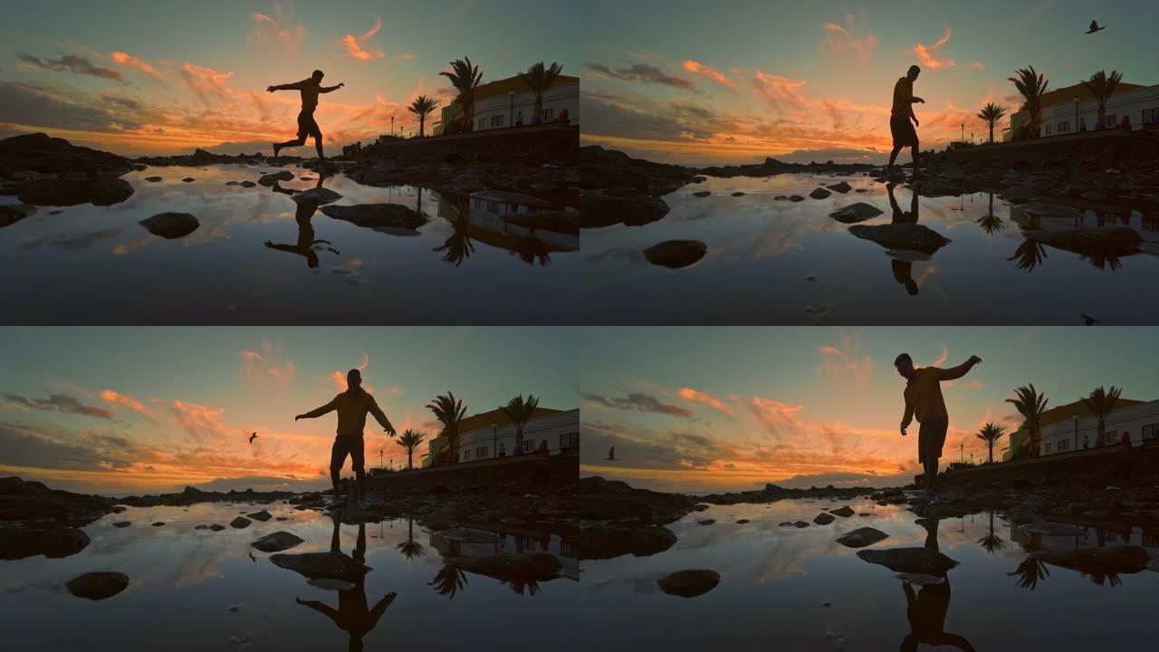 西班牙加那利群岛日落期间，男子在海滩上跳跃的全长