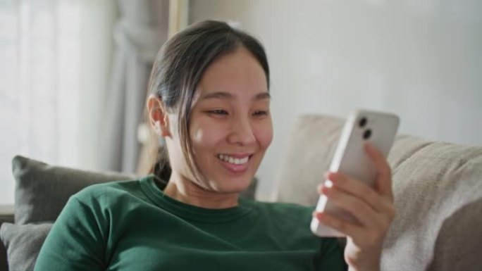 亚洲女性在沙发上使用智能手机