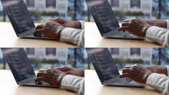 一个薄薄的现代笔记本电脑和一个年轻的黑人在键盘上输入代码的特写镜头