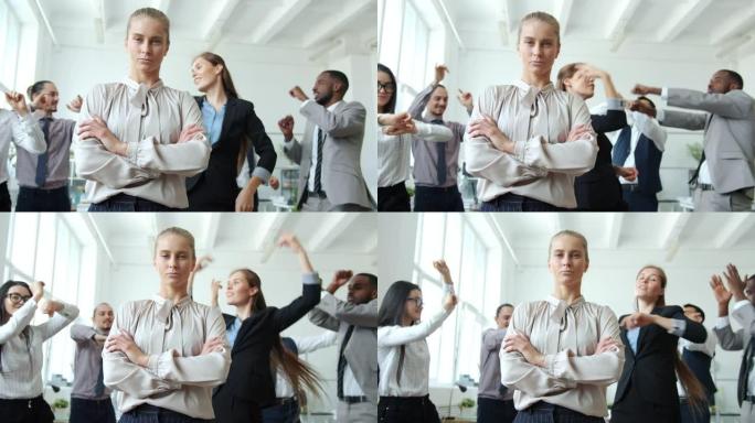 当员工在公司聚会上跳舞时，企业主面容严肃地站在办公室