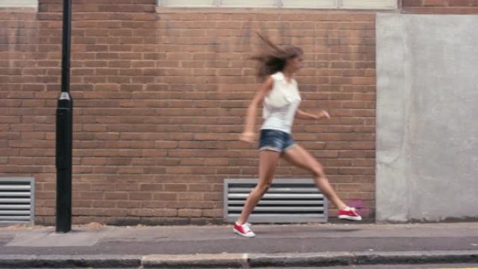 4k视频片段，一名年轻女子在城市背景下跳舞