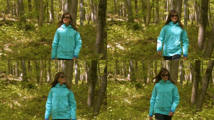 郁郁葱葱的春天-唤醒的森林，开朗的女士走在绿色的山毛榉树旁