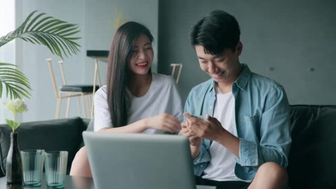 快乐的年轻亚洲夫妇在家网上购物