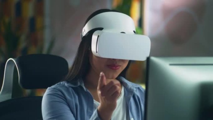 在电脑上工作的虚拟现实耳机中的女人