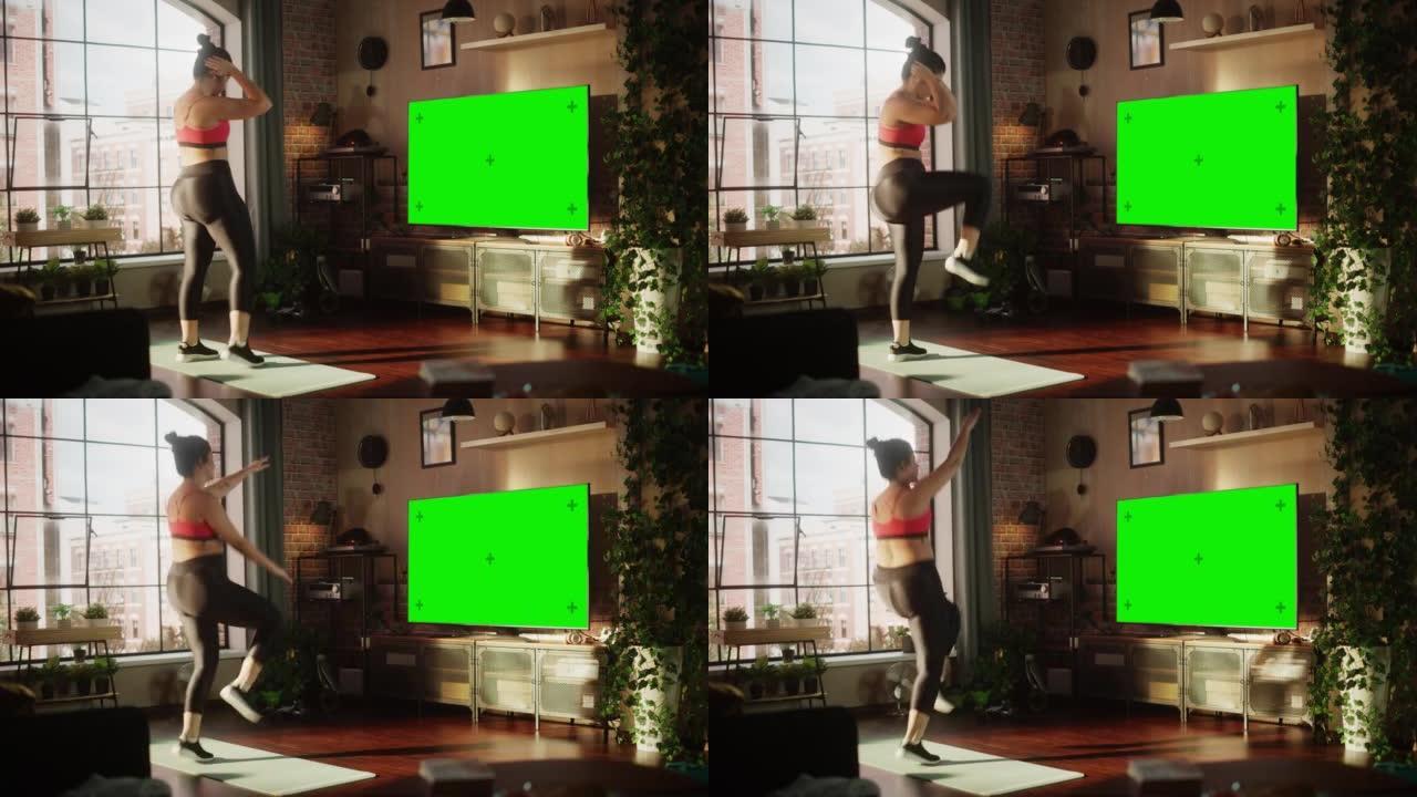 家庭健身房: 使用绿色模拟电视屏幕进行华丽大码积极的女孩训练。正宗的女人使用健身服务应用程序，用色键