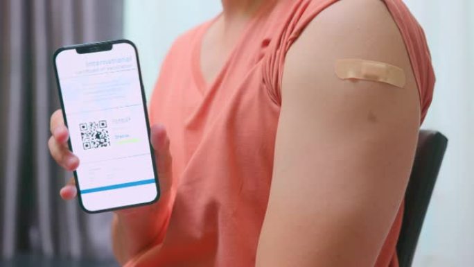 特写亚洲男子在接种疫苗后在智能手机上展示国际新型冠状病毒肺炎疫苗接种证书