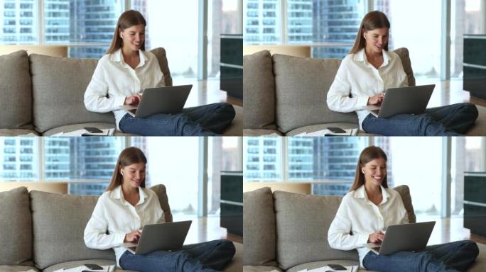 女人坐在沙发上使用笔记本电脑，通过可视电话聊天