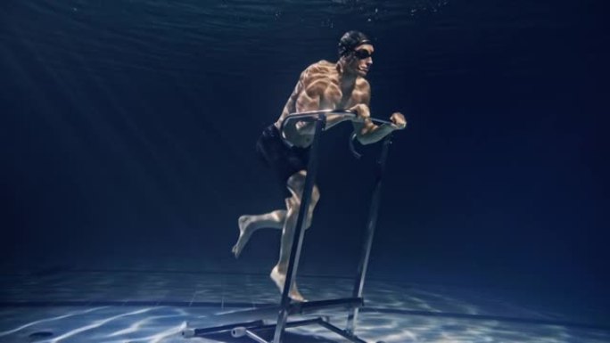 年轻的男性运动员的电影镜头肌肉发达，正在水下固定跑步机上努力和决心地锻炼。运动、健身、健康生活方式、