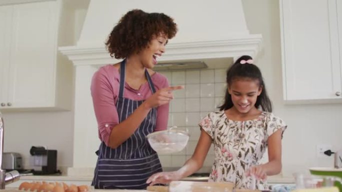 非裔美国母亲和女儿在家里的厨房里一起烘烤