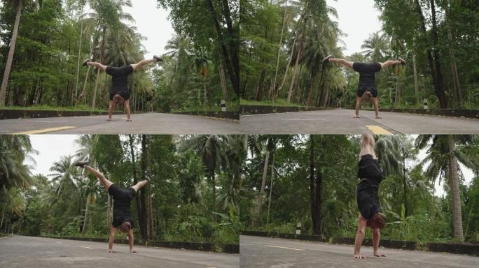 男子练习倒立热带雨林棕榈树林间公路