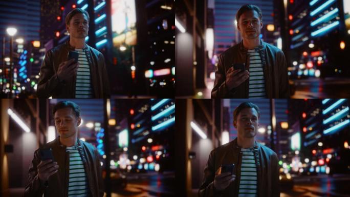 男人使用智能手机走过充满霓虹灯的夜晚城市街道。微笑的时尚男人使用手机，社交媒体，在线购物，在约会应用
