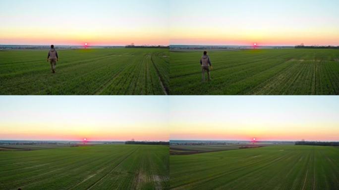 SLO MO空中农民在黄昏时在田野上行走