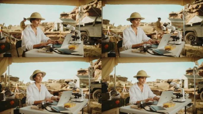 考古挖掘地点: 美丽的女性考古学家进行研究，使用笔记本电脑，用显微镜分析化石遗骸。历史学家发掘伟大多