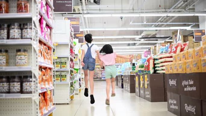 一个亚洲华裔年轻姐妹兄弟姐妹站在超市内的镜头前