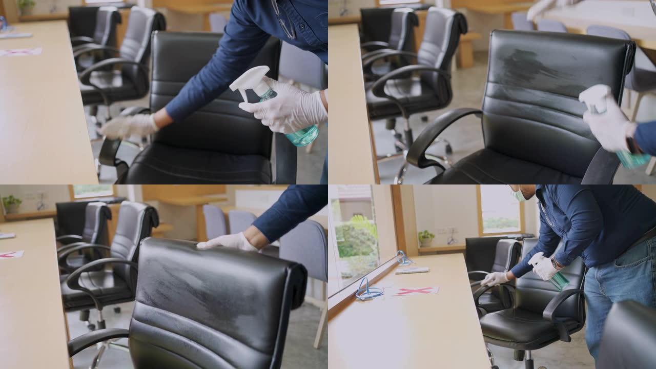 男子戴着口罩和塑料手套使用气溶胶喷雾酒精清洁办公椅在新型冠状病毒肺炎病毒