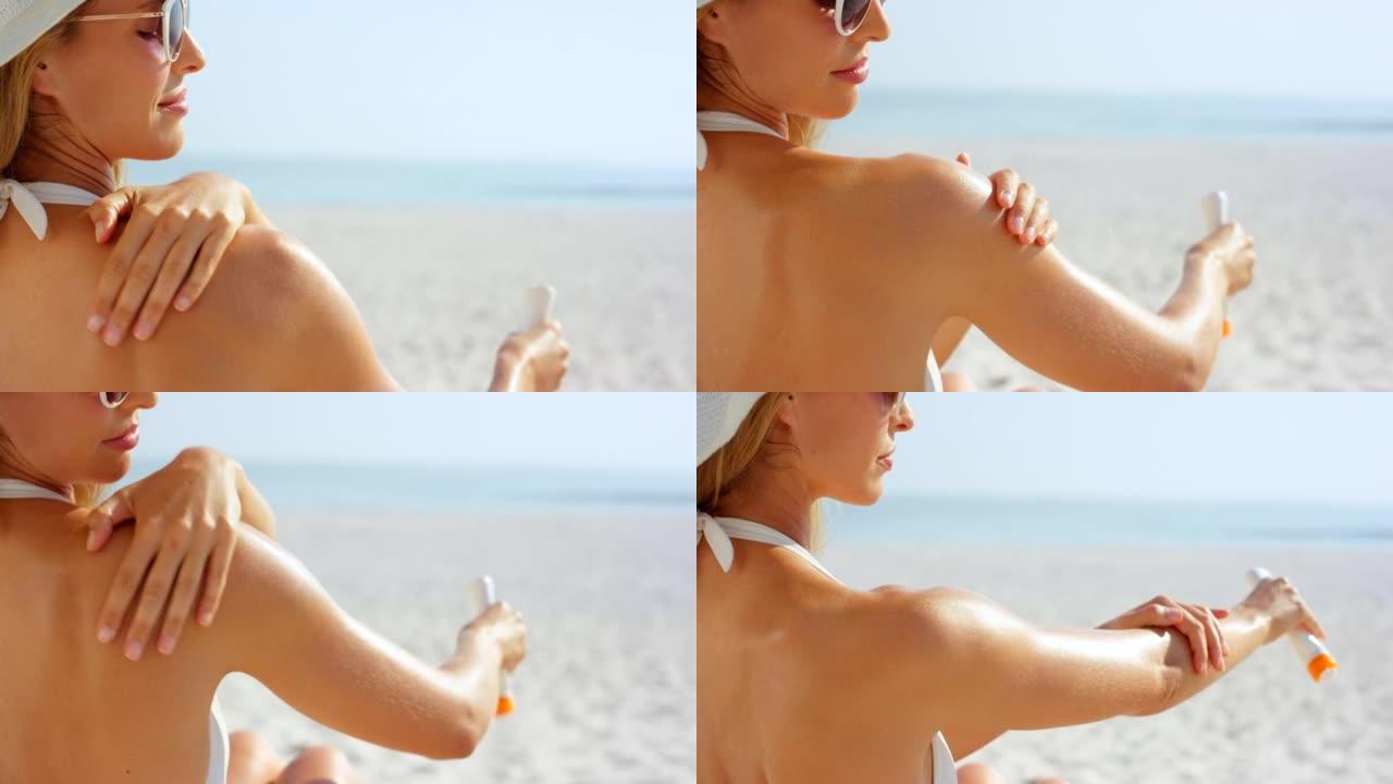 4k视频片段，一名妇女在海滩上给自己的身体涂防晒霜