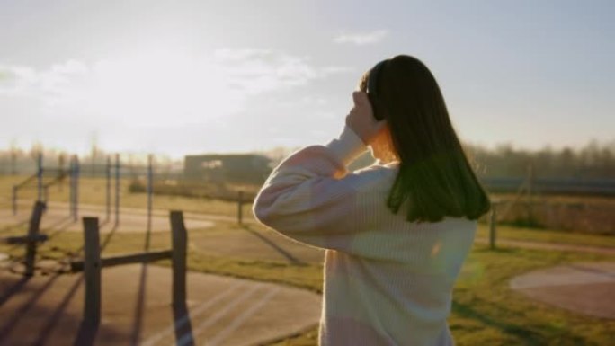 幸福女人在训练场上使用耳机听音乐