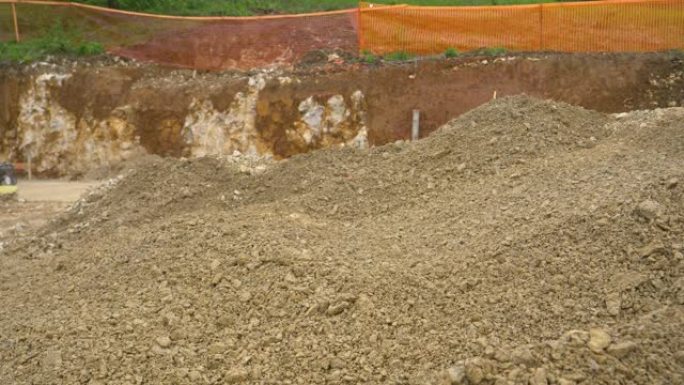 特写: 推土机开起一堆湿砾石，用铲斗铲起。