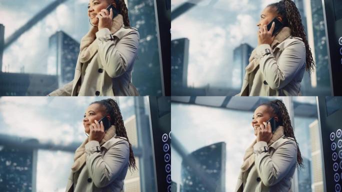 成功的黑人成年女性乘坐玻璃电梯到现代商务中心的办公室。美丽的非洲裔美国经理在电话里聊天，在电梯里接一