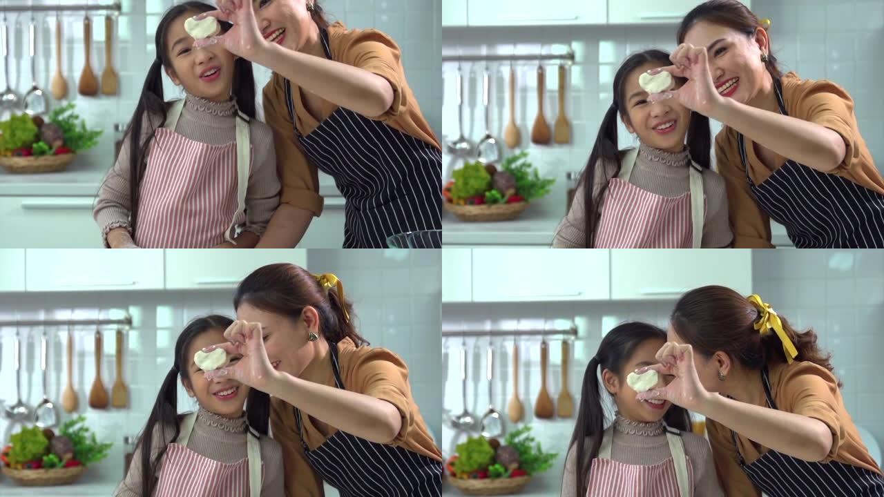 亚洲母女俩互相帮助做面包或在厨房里烤得很开心。反映了母亲与女儿的爱。