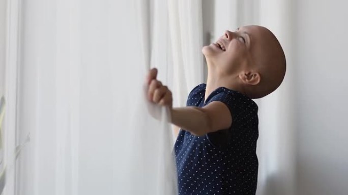 站在窗户附近的癌症患者看着外面呼吸新鲜空气