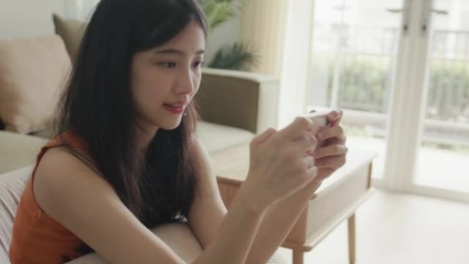 年轻女子在智能手机上玩网络游戏。