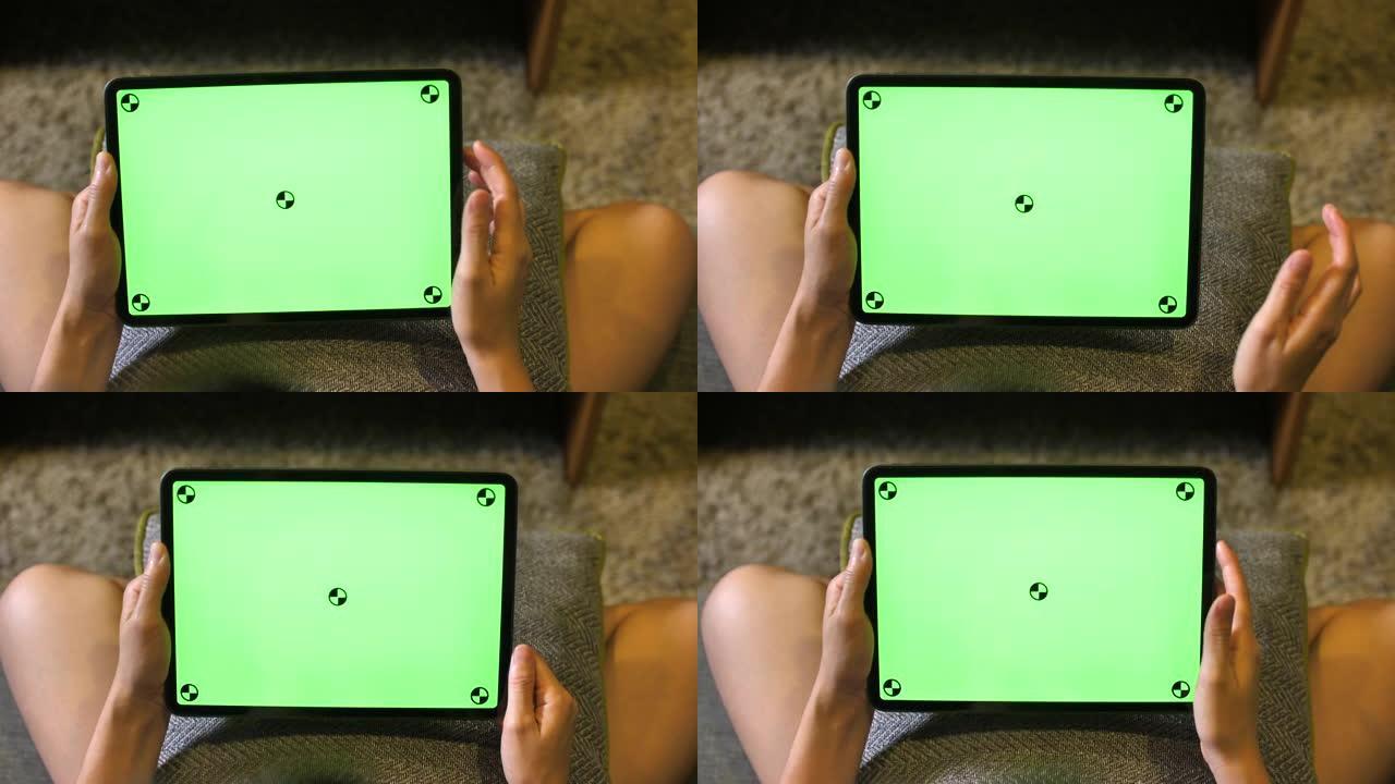 女人在绿色模拟屏幕数字平板电脑上握着并使用手势
