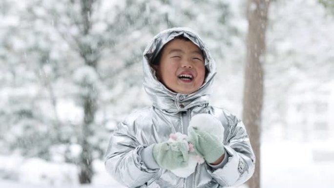 蹒跚学步的小男孩在冬天玩雪